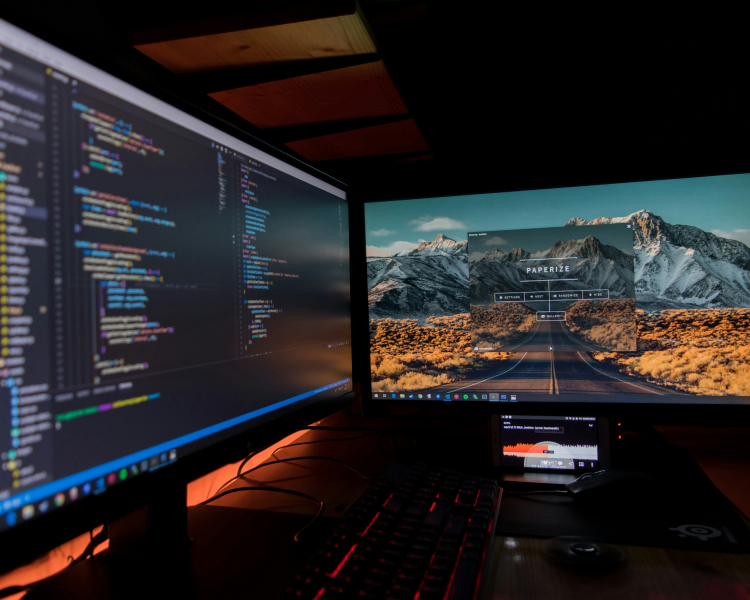 ノートパソコンでコーディング作業をしている手元と画面